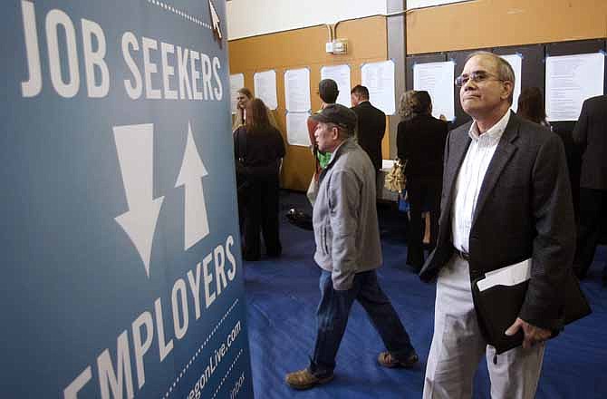 In this April 24, 2012, file photo, job seeker Alan Shull attends a job fair in Portland, Ore. The Labor Department said Friday, May 4, 2012, that the economy added just 115,000 jobs in April.
