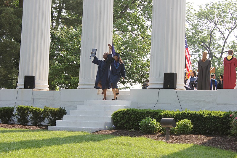 The first two students walk triumphantly through the columns during the Columns Ceremony following Westminster College's 2012 commencement ceremony. Students walk through the columns toward the school during their freshman year, and again cross through them toward the world following graduation.
