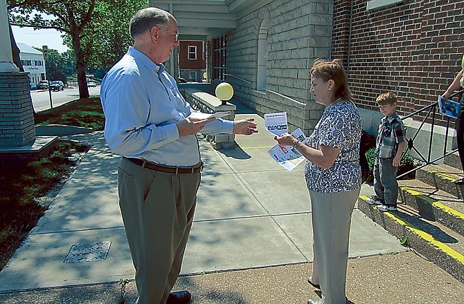 Michael Wegs hands out a flyer to Immaculate Conception Church members after church Sunday morning. The flyers ask area leaders of the church to "break the silence" of sex abuse at the former St. Thomas Seminary in Hannibal. 