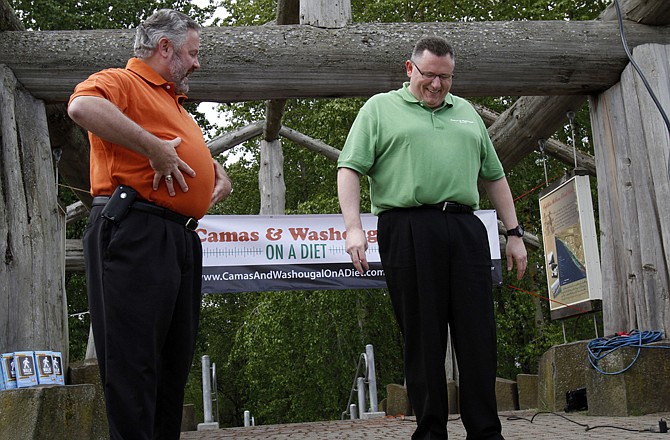 Washougal Mayor Sean Guard, left, coaxes Camas Mayor Scott Higgins to step on the scales during their weigh-in in Washougal, Wash. 