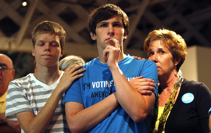 Seth Keel, center, is consoled by his boyfriend, Ian Chambers and his mother, Jill Hinton, during a concession speech at an Amendment One opposition party Tuesday, in Raleigh, N.C. North Carolina voters approved the constitutional amendment Tuesday defining marriage solely as a union between a man and a woman.