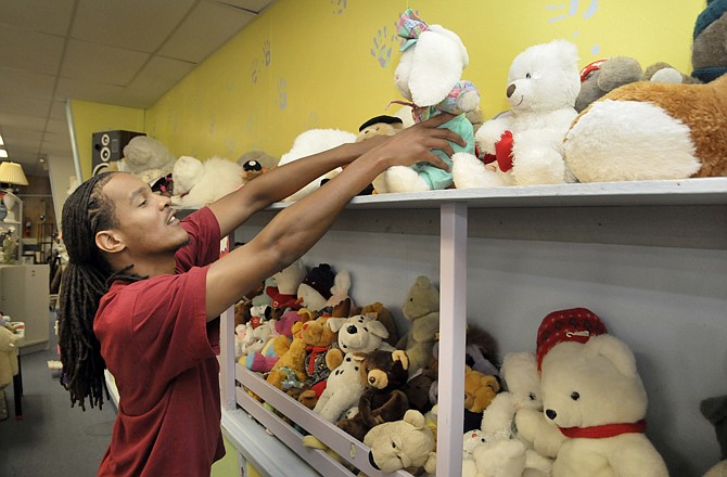 Andrew "Smiley" Sutherland arranges the stuffed animal display at the Salvation Army Thrift Store on Wednesday.