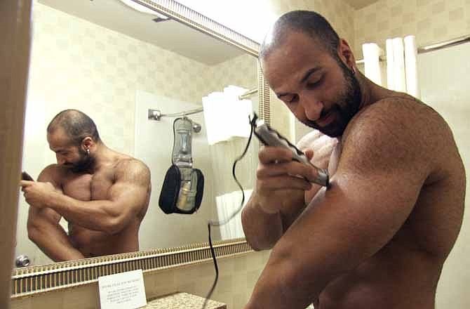 In image released by Warrior Poets, Shawn Daivari shaves his arms in a scene from "Mansome."