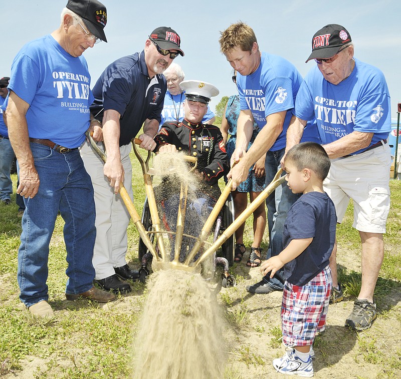 
Those involved in helping build a new house for Marine Cpl. Tyler Huffman, center, break ground at the site of construction. The shovel was wielded by (from left) Joe Twehous, Frank Siller, Scott Schaeperkoetter and Pete Adkins. Huffman's son, Matthew, joined in.