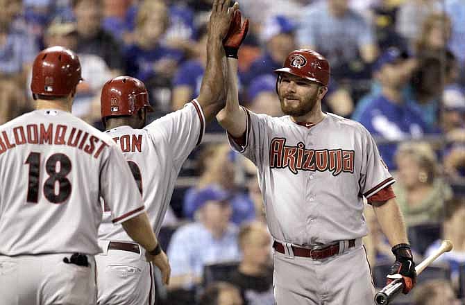 Arizona Diamondbacks' Justin Upton and Willie Bloomquist (18) celebrate with Jason Kubel, right, after the first two scored on a hit by Chris Young during the sixth inning of a baseball game against the Kansas City Royals on Friday, May 18, 2012, in Kansas City, Mo.