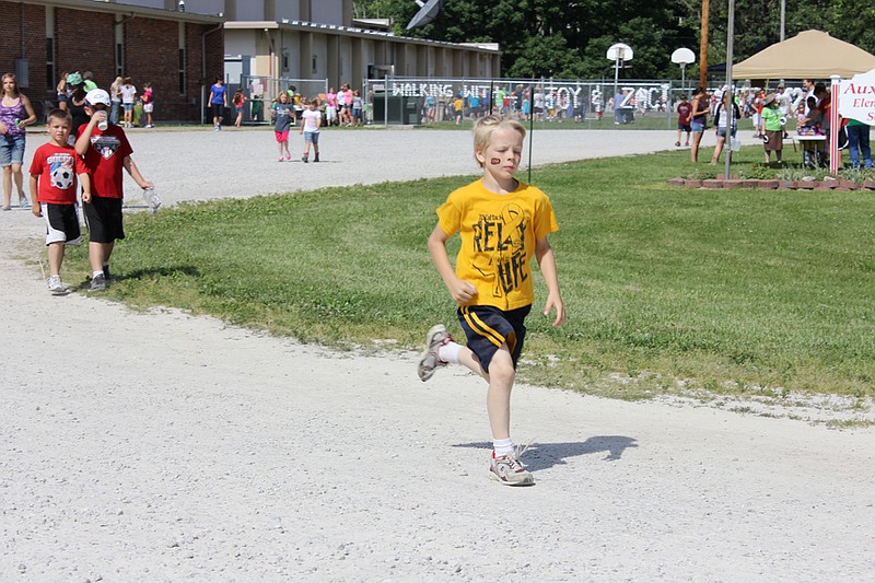 An Auxvasse Elementary student makes a lap around the bus track in front of the school for this year's "Walking With Joy and Zac" event. Named for a former teacher and student who passed away of cancer, the miniature Relay for Life event serves as a chance for students to take a break from studies and raise funds for a worthy cause.

