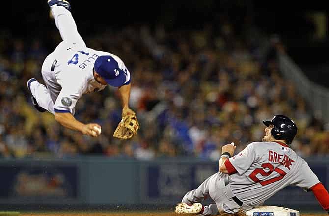 Los Angeles Dodgers second baseman Mark Ellis goes flying after colliding with St. Louis Cardinals runner Tyler Greene, out on a fielder's choice - Shane Robinson reached first - in the seventh inning of a baseball game in Los Angeles Friday, May 18, 2012. 