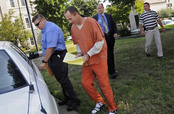 In this Aug. 23, 2011, photo Clay Waller, center, is escorted to a police vehicle after a court hearing at the Cape Girardeau County Courthouse in Jackson, Mo., where he appeared on charges of stealing and harassment. Waller, 41, was charged Monday, April 23, 2012, with first-degree murder in the death of his estranged wife Jacque Waller, even though her body has not been found. Waller was 39 when she disappeared June 1, 2011.