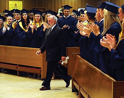 Helias seniors give longtime teacher and coach Mike Jeffries a standing ovation as he prepares to present the Mike Jeffries Service Award at Sunday's graduation.