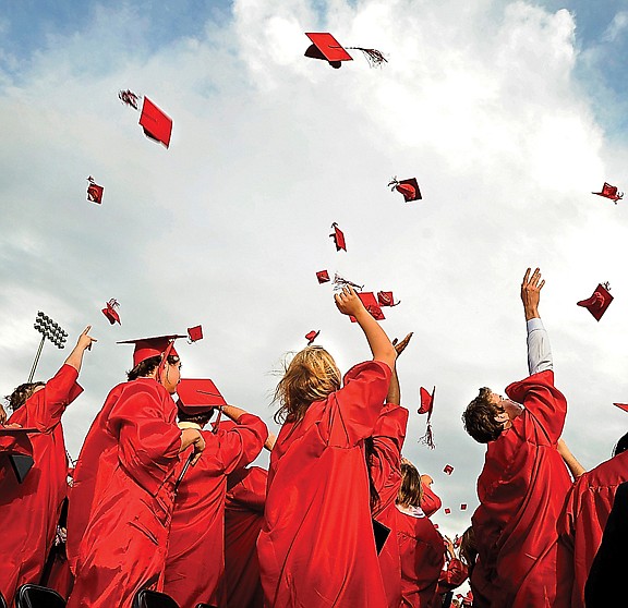 Members of the Jefferson City High School class of 2012 toss their caps into the air following the conclusion of Sunday's graduation ceremony.