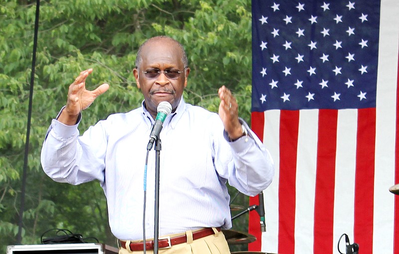 Herman Cain, left, greets the crowd during his appearance Saturday near Holts Summit at the Rally for Common Sense. In his speech to the group Cain urged them to vote in November to make sure President Obama is not re-elected. 