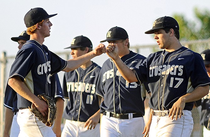 Helias teammates Blake Monson (left) and Zach Backes celebrate after the end off the sixth inning in Tuesday's Class 4 sectional game against Rock Bridge at the American Legion Sports Complex.