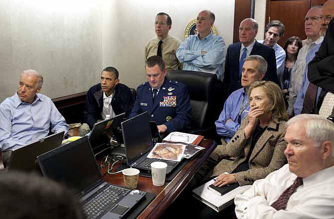 In this May 1, 2011, image released by the White House and digitally altered by the source to obscure the details of a document in front of Secretary of State Hillary Rodham Clinton, at right with hand covering mouth, President Barack Obama, second from left, Vice President Joe Biden, left, Secretary of Defense Robert Gates, right, and members of the national security team watch an update on the mission that killed Osama bin Laden in the Situation Room of the White House in Washington. 