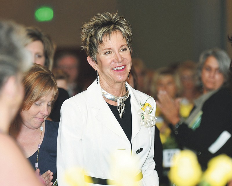 Jahnae Barnett, president of William Woods University, makes her way to the stage to accept her Women of Achievement Award Tuesday during the annual Yellow Rose Luncheon, hosted by Zonta.
