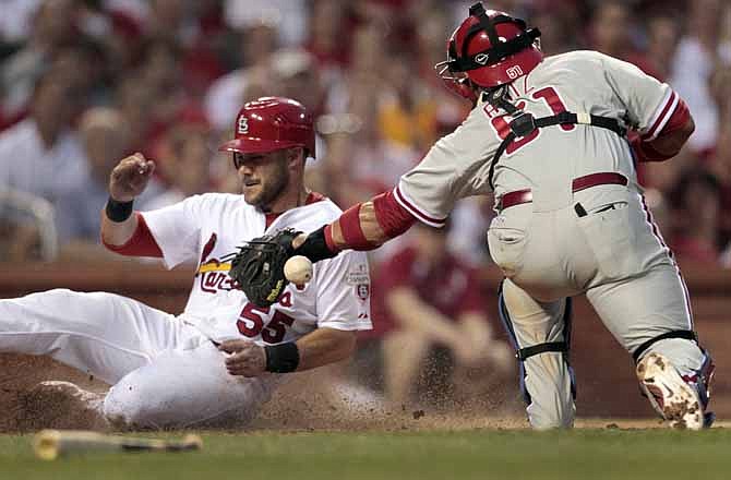 St. Louis Cardinals' Skip Schumaker, left, is safe at home as the throw gets away from Philadelphia Phillies catcher Carlos Ruiz during the third inning of a baseball game Thursday, May 24, 2012, in St. Louis.