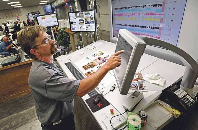 Pressman Randy Schmitz operates the command console for Modern Litho's brand new multimillion dollar Heidelberg S press during an open house celebration marking the company's 75th anniversary on Thursday. 