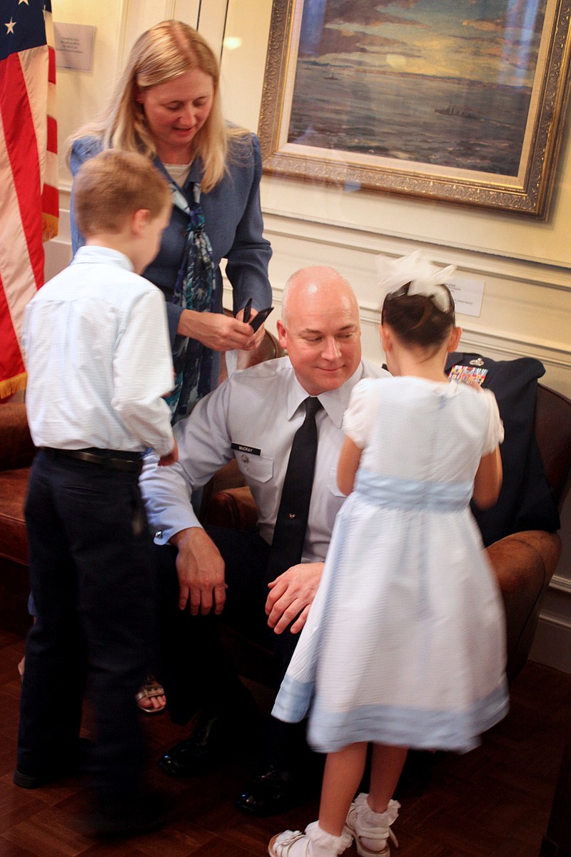 Gerald McCray's wife, Dottie, and children, Alaina, 7, and Cody, 6, pin his new colonel rank to his jacket at a pinning-on ceremony Wednesday in the Churchill Museum.