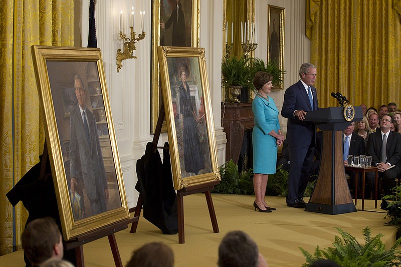 Former President George W. Bush and former first lady Laura Bush stand on stage Thursday in the East Room of the White House in Washington, during the unveiling ceremony of their portraits.