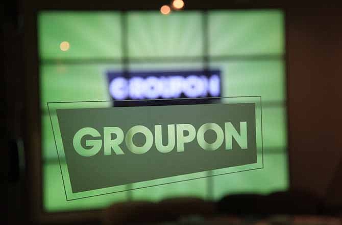 In this Thursday, Sept. 22, 2011, file photo, the Groupon logo is etched in glass in the lobby of the online coupon company's Chicago offices. Groupon's stock is tumbling as insiders are selling their shares after a post-IPO prohibition was lifted.