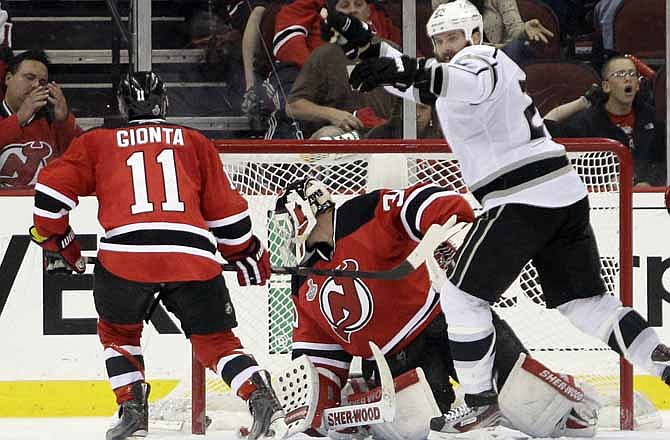 Los Angeles Kings' Dustin Penner, right, celebrates after teammate Jeff Carter scored a goal past New Jersey Devils' Martin Brodeur during the overtime period of Game 2 of the NHL hockey Stanley Cup finals on Saturday, June 2, 2012, in Newark, N.J. Devis' Stephen Gionta, left, looks on. The Kings won the game 2-1. 