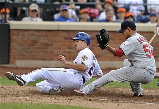 New York Mets' Daniel Murphy,left, scores at home plate past St. Louis Cardinals relief pitcher Eduardo Sanchez (52) on a wild pitch in the seventh inning of a baseball game on Saturday, June 2, 2012, at Citi Field in New York.