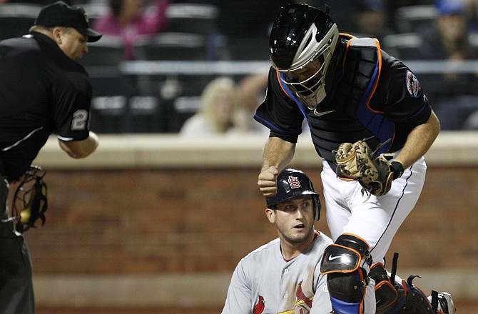 David Freese of the Cardinals sits in the dirt after being tagged out at home by Mets catcher Josh Thole in the sixth inning of Sunday night's game in new York. Freese had tried to score from second on a single by Adron Chambers, but was thrown out by Andres Torres.