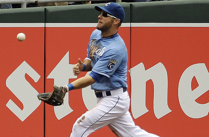 The Royals' Alex Gordon makes a catch before throwing home for a double play against the A's on Sunday in Kansas City.