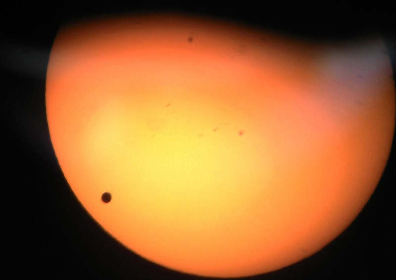 Venus, lower left, travels between the sun and the Earth, in what is known as a Venus transit, in this image taken through a telescope on Tuesday at Central Lakes College in Brainerd, Minn.