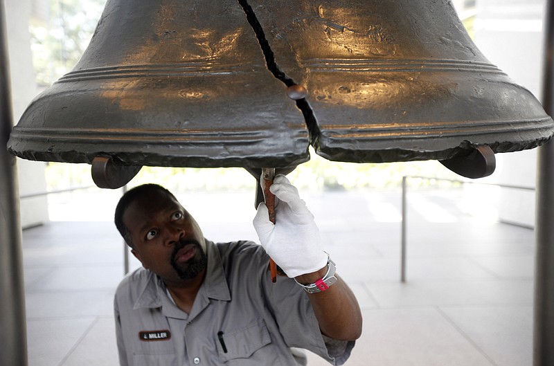 Technician Jonathan Miller applies protective wax as part of regular conservation work Thursday on the Liberty Bell at Independence National Historical Park in Philadelphia.