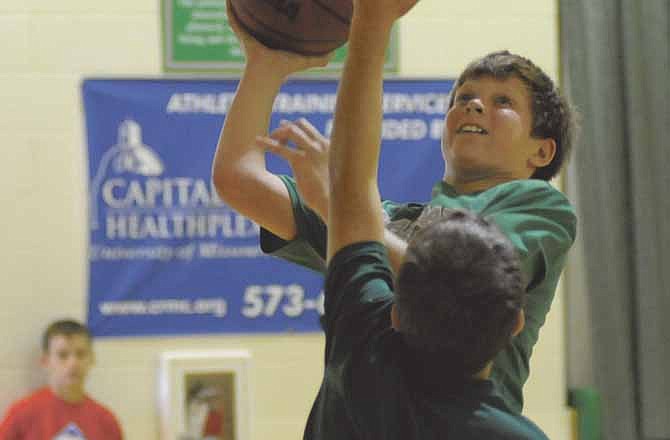 Gary Freeman looks to take a shot against Jason Rackers during the the one-on-one King of the Court tournament during basketball camp at Blair Oaks High School.