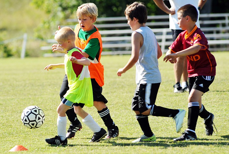 (From left) Zach Paschal, Seth Stumbaugh, Logan Wilson and Caleb Mueller pursue the ball during this week's Helias boys soccer camp at the 179 Soccer Park.