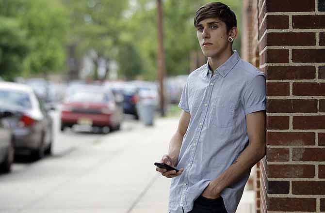 Dylan Young, 18, poses for The Associated Press as a vehicle cruises by, Wednesday, June 6, 2012, in North Arlington, N.J. Young, a senior at North Arlington High, was in a fender-bender accident caused by being distracted while texting and driving. More than half of high school seniors say they text or email while driving, according to a jarring new study that offers the first federal statistics on how common the dangerous habit is in teens.