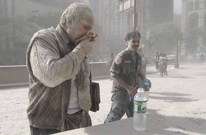 In this Sept. 11, 2001 file photo, a man wipes ash from his face after terrorists flew two airplanes into the World Trade Center towers, causing them to collapse. 