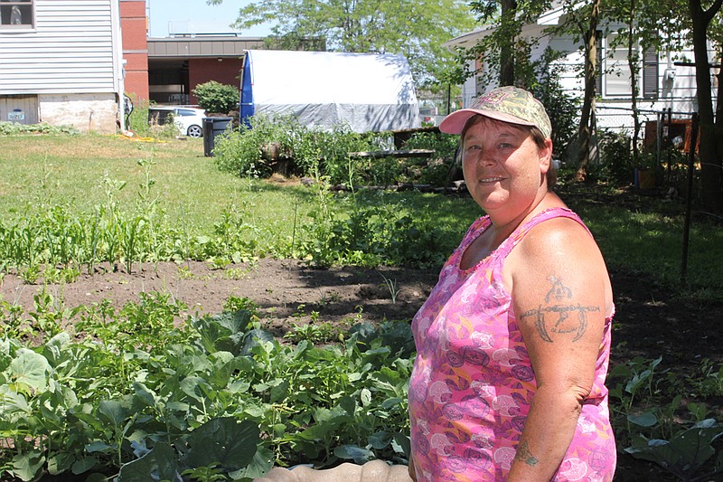 Stephanie "Frog" Stambaugh poses in just a portion of her garden at her home on Nichols Street. Stambaugh grows several varieties of fruits and vegetables, which she often shares with members of the community.