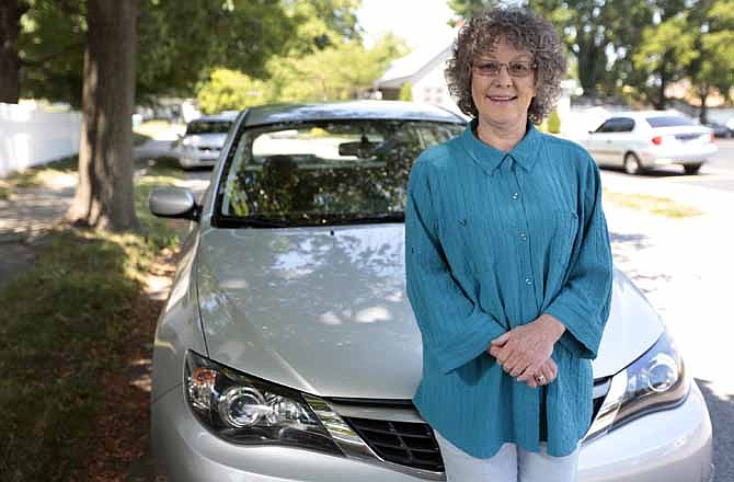 Cindy Shriner, a retired teacher, poses for a portrait with her 2009 Subaru Impreza in Lafayette, Ind., Saturday, June 9, 2012. Shriner buys energy-efficient light bulbs and her car gets nearly 30 miles per gallon on the highway. Still, she keeps her house at about 73 degrees year-round, despite government recommendations to turn thermostats to 68 degrees in winter and 78 degrees in summer. "I'm terrible," Shriner, 60, said in an interview. A new poll shows that while most of those questioned understand effective ways to save energy, they have a hard time adopting them.