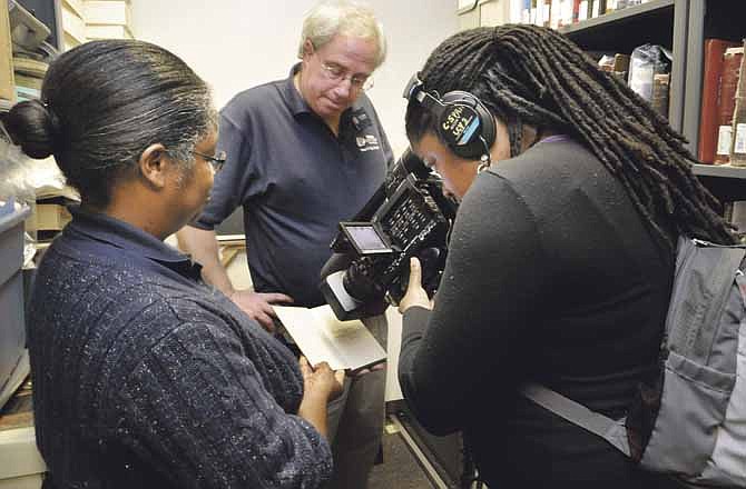 Tiffany Rocque, right, a production assistant with C-SPAN, has spent the week in Jefferson City filming historic locations and items. On Wednesday, she filmed as library archivist Mark Schleer and library assistant Ithica Bryant, left, took her on a tour of the archives at Lincoln University. 