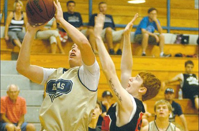Helias' Hale Hentges puts up a shot while being defended by Jefferson City's Dylan Mason during Saturday's game at Rackers Fieldhouse.