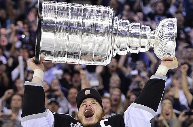 Kings captain Dustin Brown hoists the Stanley Cup at Los Angeles won the title Monday night.