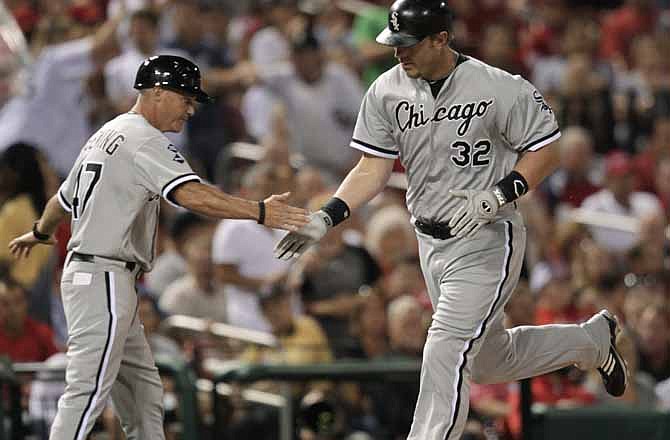 Chicago White Sox's Adam Dunn (32) celebrates with third base coach Joe McEwing after hitting a solo home run in the eighth inning of a baseball game against the St. Louis Cardinals, Tuesday, June 12, 2012 in St. Louis.