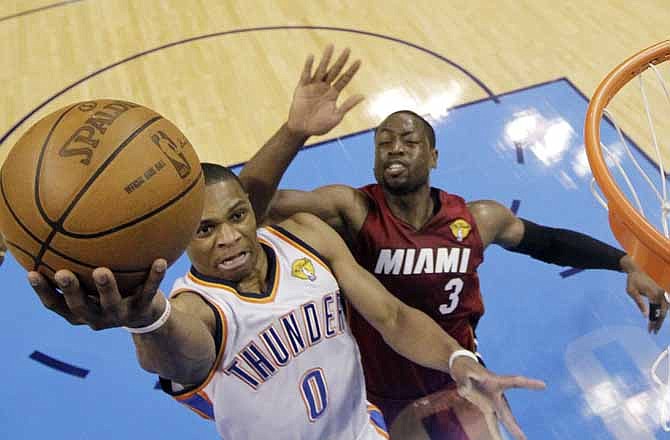 Oklahoma City Thunder point guard Russell Westbrook (0) shoots as Miami Heat shooting guard Dwyane Wade defends during the first half at Game 1 of the NBA finals basketball series, Tuesday, June 12, 2012, in Oklahoma City.