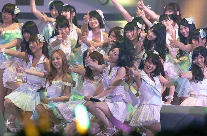 In this June 6, 2012 file photo, Japan's all-girl pop idol group AKB48 members perform during the annual AKB48 popularity poll in Tokyo. More than 60 girls and young women, split into four teams, make up what is arguably Japan's most popular pop group. It performs almost every day, has spawned affiliate groups across the country and has recently given rise to sister mega-groups in China and Indonesia.