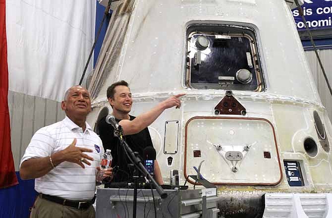 NASA Administrator Charles Bolden, left, and SpaceX CEO Elon Musk, right, answer questions in front of the SpaceX Dragon spacecraft Wednesday June 13, 2012 at the SpaceX Rocket Development Facility in McGregor, Texas. The spacecraft recently made history as the first commercial vehicle to visit the International Space Station. The California-based SpaceX is the first private business to send a cargo ship to the space station.