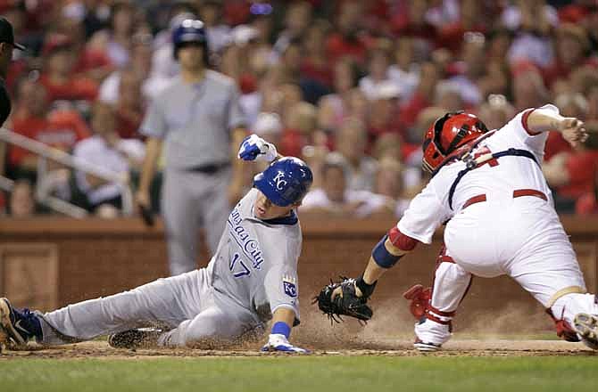 Kansas City Royals' Chris Getz (17) avoids the tag of St. Louis Cardinals catcher Yadier Molina as he scores from third on a sacrifice fly by Jeff Francoeur in the seventh inning of a baseball game, Friday, June 15, 2012 in St. Louis.