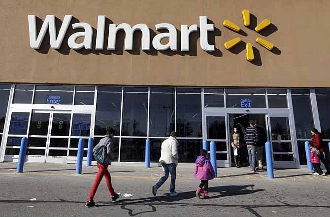 In this Feb. 20, 2012, file photo, customers walk into and out of a Wal-Mart store in Methuen, Mass. 