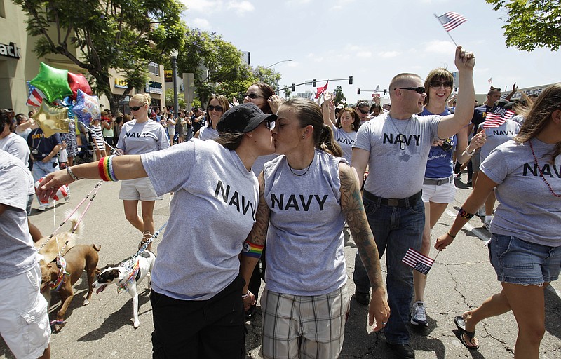 Two women, both active duty sailors in the Navy who gave their names as Nikki, left, and Lisa, kiss in July 2011 as they march in the Gay Pride Parade in San Diego. Defense Secretary Leon Panetta is thanking gay military members for their service, as the Pentagon prepares to mark June as gay pride month with an official salute.