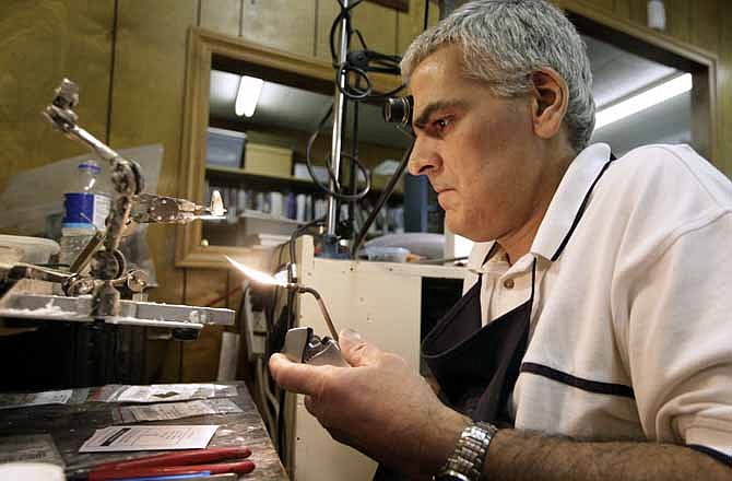 In this Thursday, June 14, 2012 photo, Mike Lamm works on a ring in his jewelry shop in Mediapolis, Iowa. These days, people aren't buying much jewelry. What saves him is his ability to repair watches and make rings. There's still enough call for that kind of work in the small town in rural southeastern Iowa. 