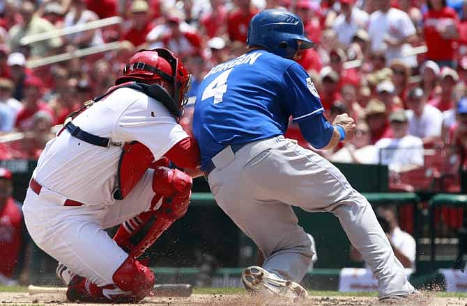 St. Louis Cardinals catcher Yadier Molina, left, tags out Kansas City Royals' Alex Gordon (4) at home during the first inning of a baseball game Saturday, June 16, 2012, in St. Louis. 