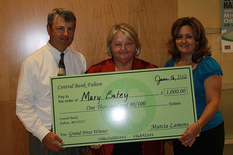 Central Bank button drawing winner Mary Batey endured pouring rain Saturday night to hear her name drawn for the big $1,000 prize. From left: Matt Gowin, Mary Batey, Ronda Miller.