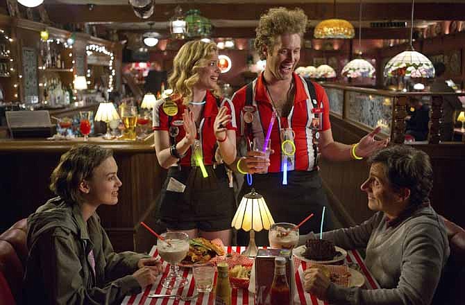 This film image released by Focus Features shows, from left, Keira Knightley as Penny, Gillian Jacobs as Katie, T.J. Miller as Darcy the Chipper Host, and Steve Carell as Dodge in a scene from "Seeking A Friend for the End of the World."