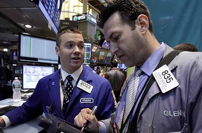 In this Monday, June 11, 2012, file photo, Specialist Frank Masiello, left, and trader Glenn Kessler work on the floor of the New York Stock Exchange.